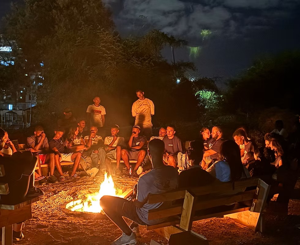 בני נוער מתאספים סביב מדורה בלילה