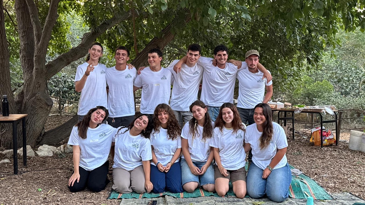 נערים ונערות של חוות אדמה לבושים בלבן עומדים בשתי שורות