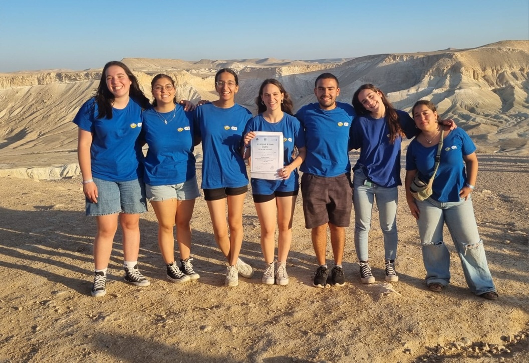 נערים ונערות לבושים כחול עומדים עם רקע מדברי