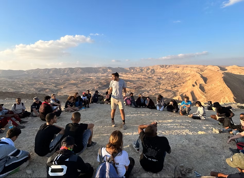 מסביר עומד בתוך עיגול ומסביר לחניכים במכינה חצי שנתית של ארגון עושים שכונה