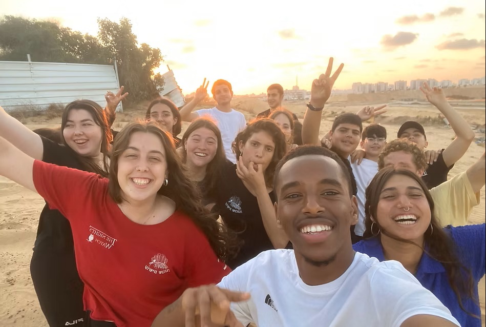 פעילות של בני ובנות נוער מארגון עושים שכונה ולידם בניינים