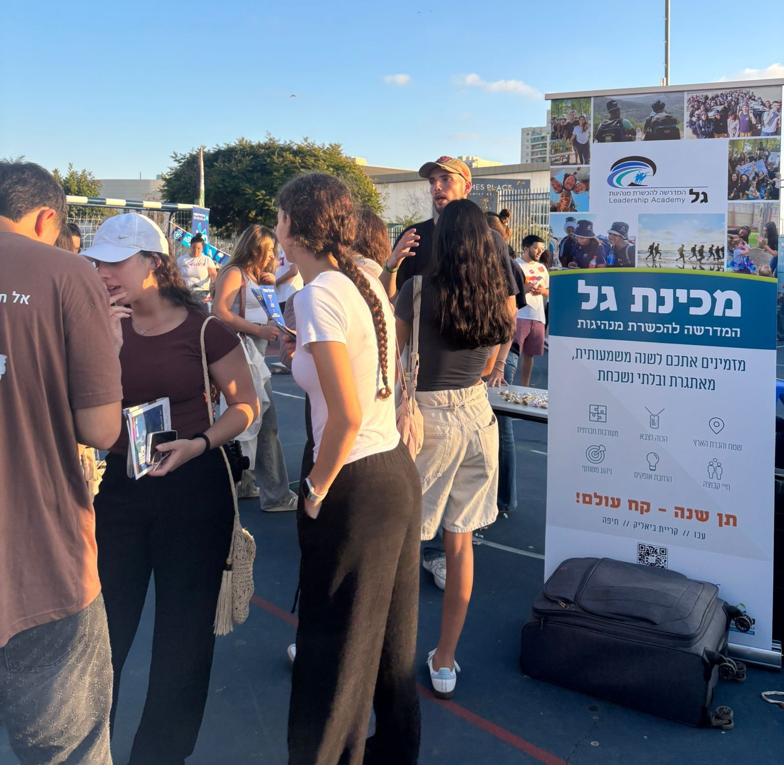 בני נוער בכנס שנת שירות באשדוד ושלט שכתוב עליו "מכינת גל"
