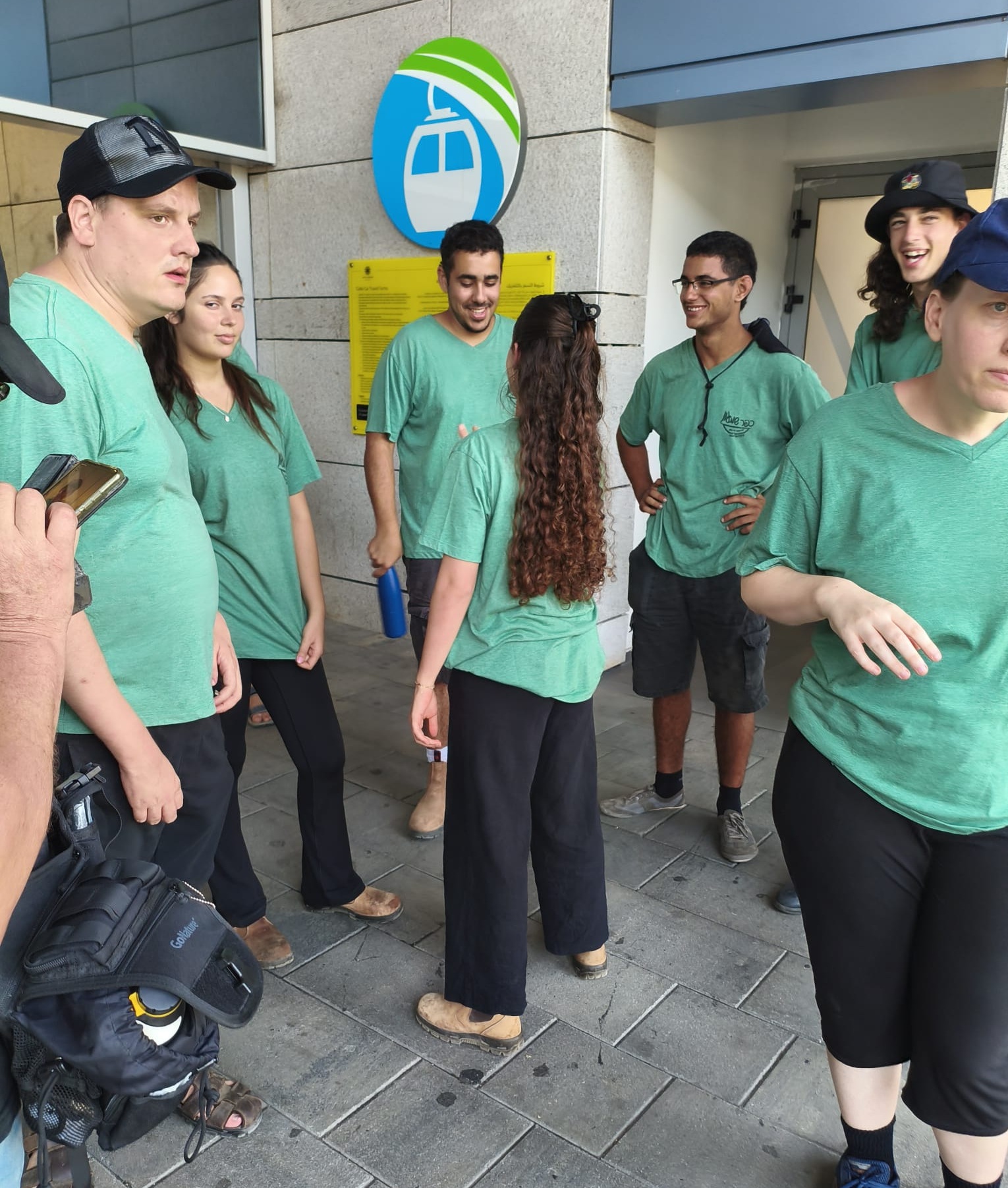 אנשים עם מוגבלות עומדים לובשים חולצות ירוקות