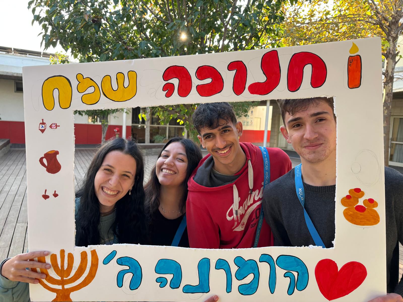 שינשינים של אלו"ט מחזיקים שלט עם הכיתוב חנוכה שמח