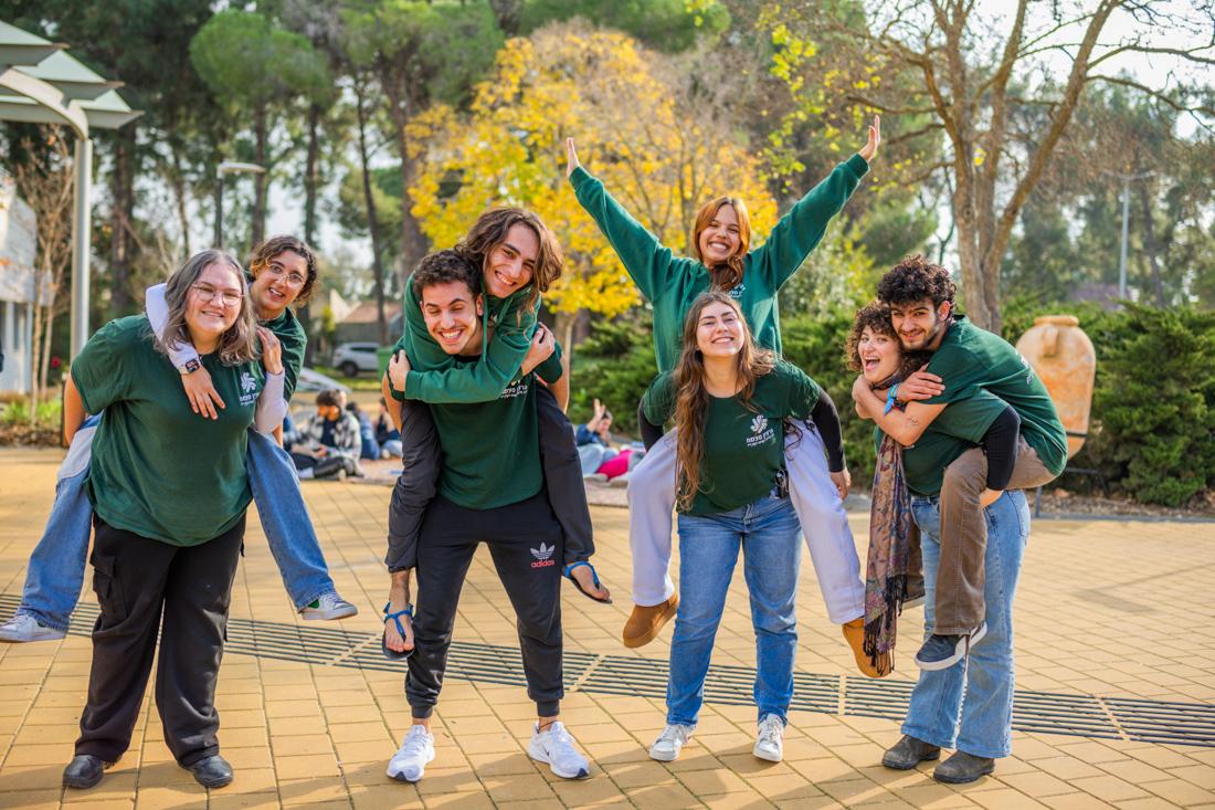 נערים ונערות מצטלמים בטבע ועצים מאחוריהם